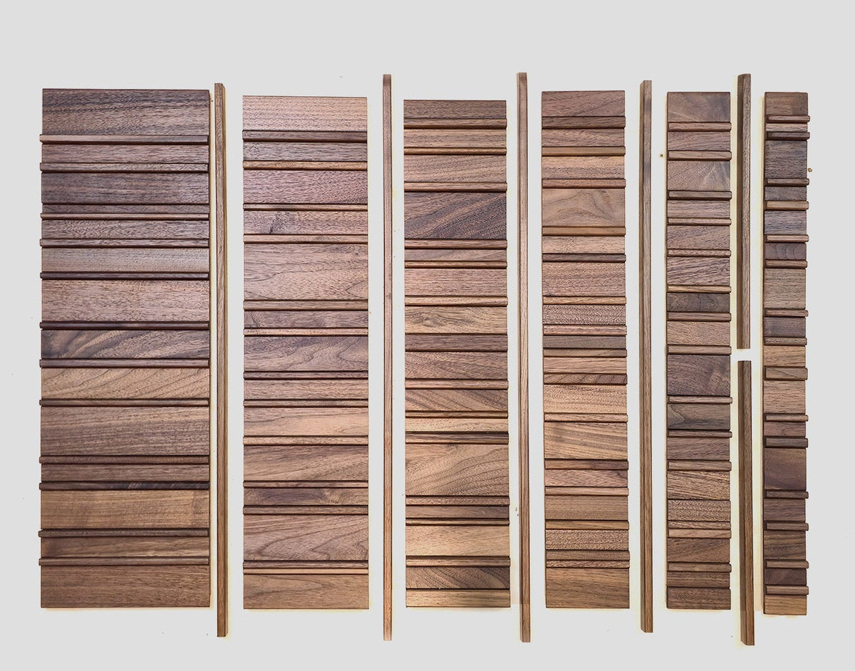A set of vertical wooden slat panels in various wood tones and grain patterns, arranged in six columns against a solid light gray background.
