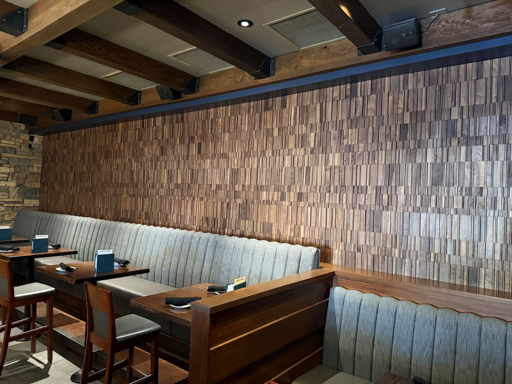 Restaurant interior with wooden walls, booths, and tables.