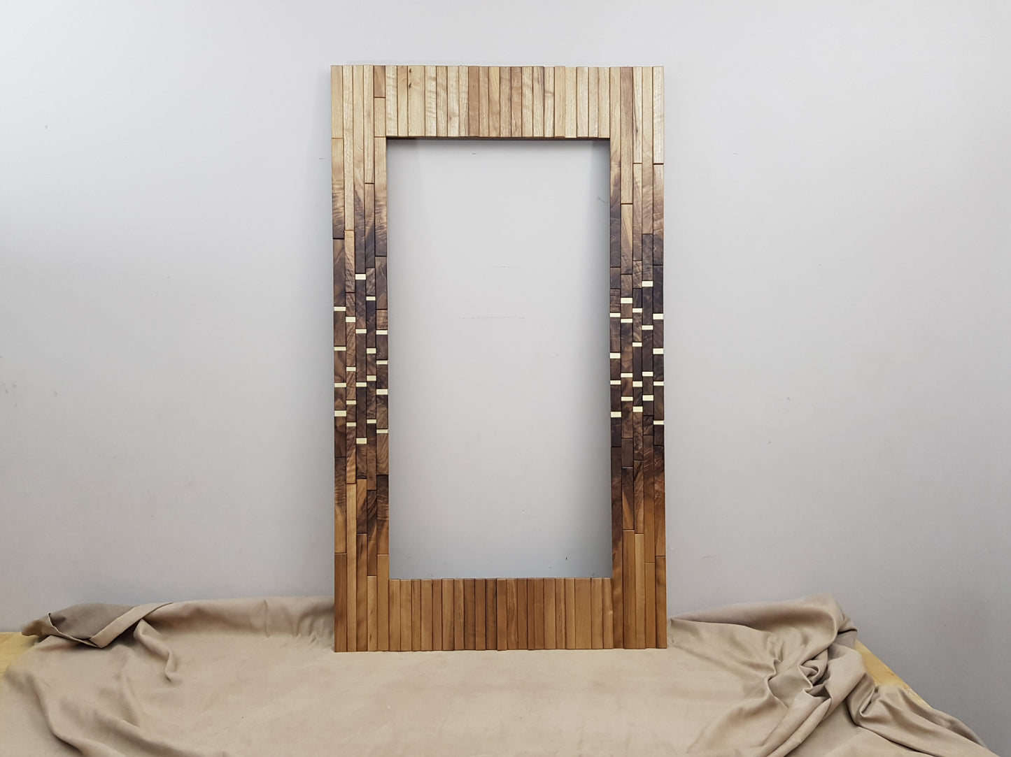 Modern centrepiece statement mirror frame in figured walnut and brass