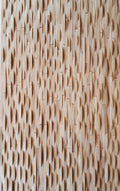 A close-up image of a 3D wavy wall cladding made from oak wood strips, finished with a matte hard wax oil.